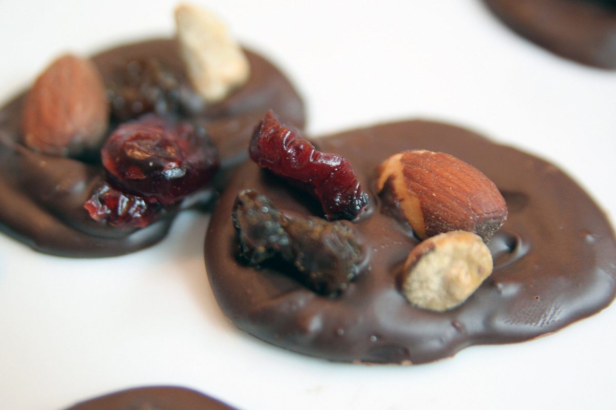 Dark chocolate discs topped with nuts, raisins, and candied orange peel