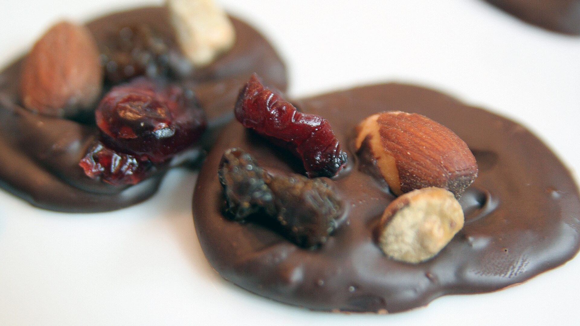 Dark chocolate discs topped with nuts, raisins, and candied orange peel