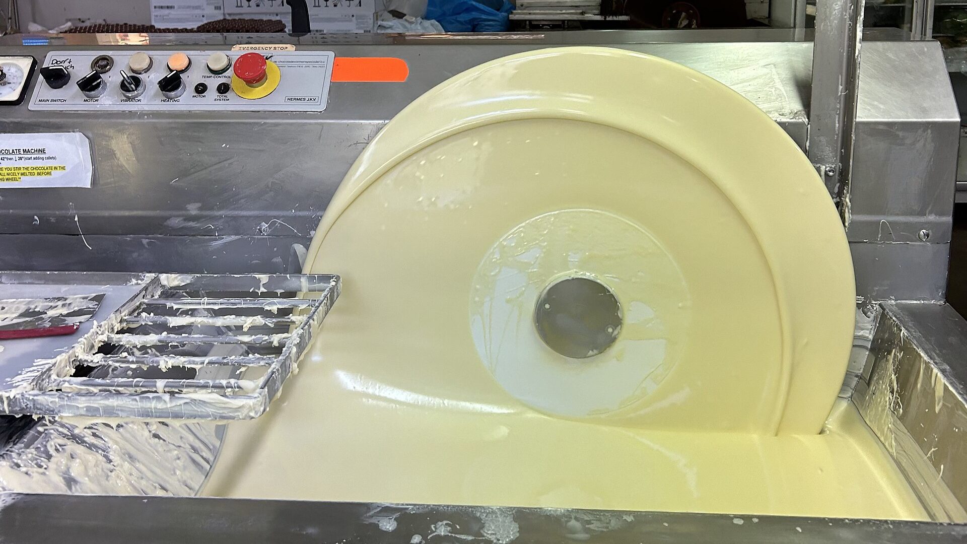 White chocolate being tempered in a mechanical tempering wheel